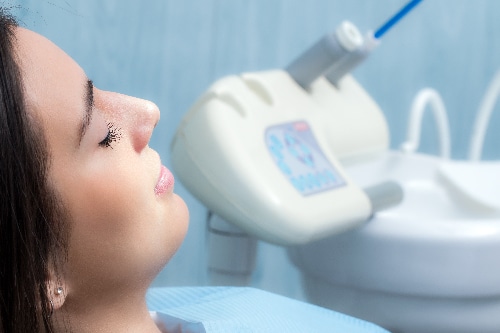 female patient sitting relaxed in a dental chair, sedation dentistry