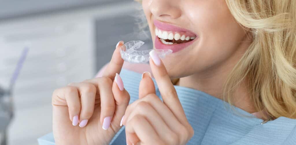 closeup of a young woman putting in her clear aligners
