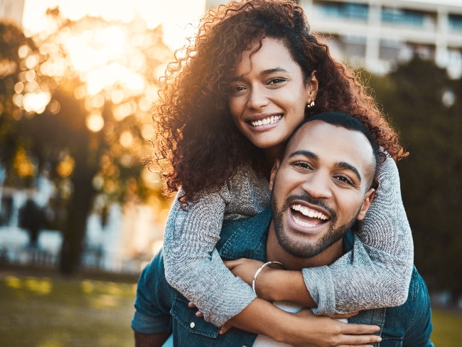 couple smiling in a park, perfect teeth