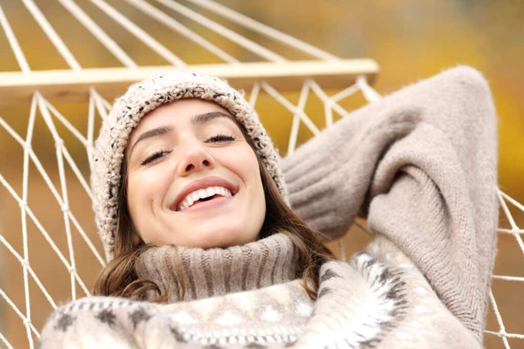 happy woman smiling on hammock, perfect white teeth